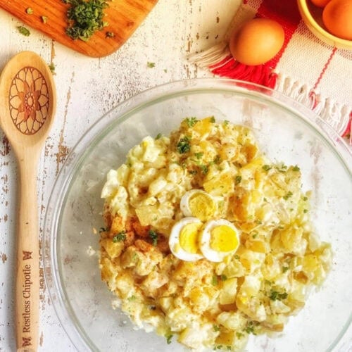 Overhead view of potato salad in a glass bowl