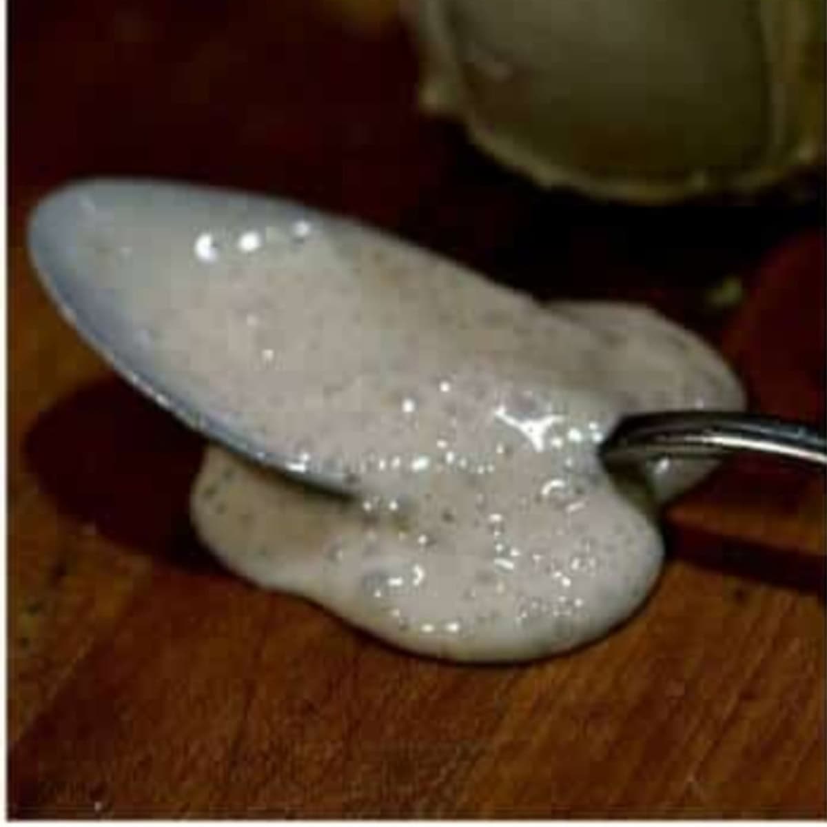 Closeup of a spoon covered in sourdough starter.