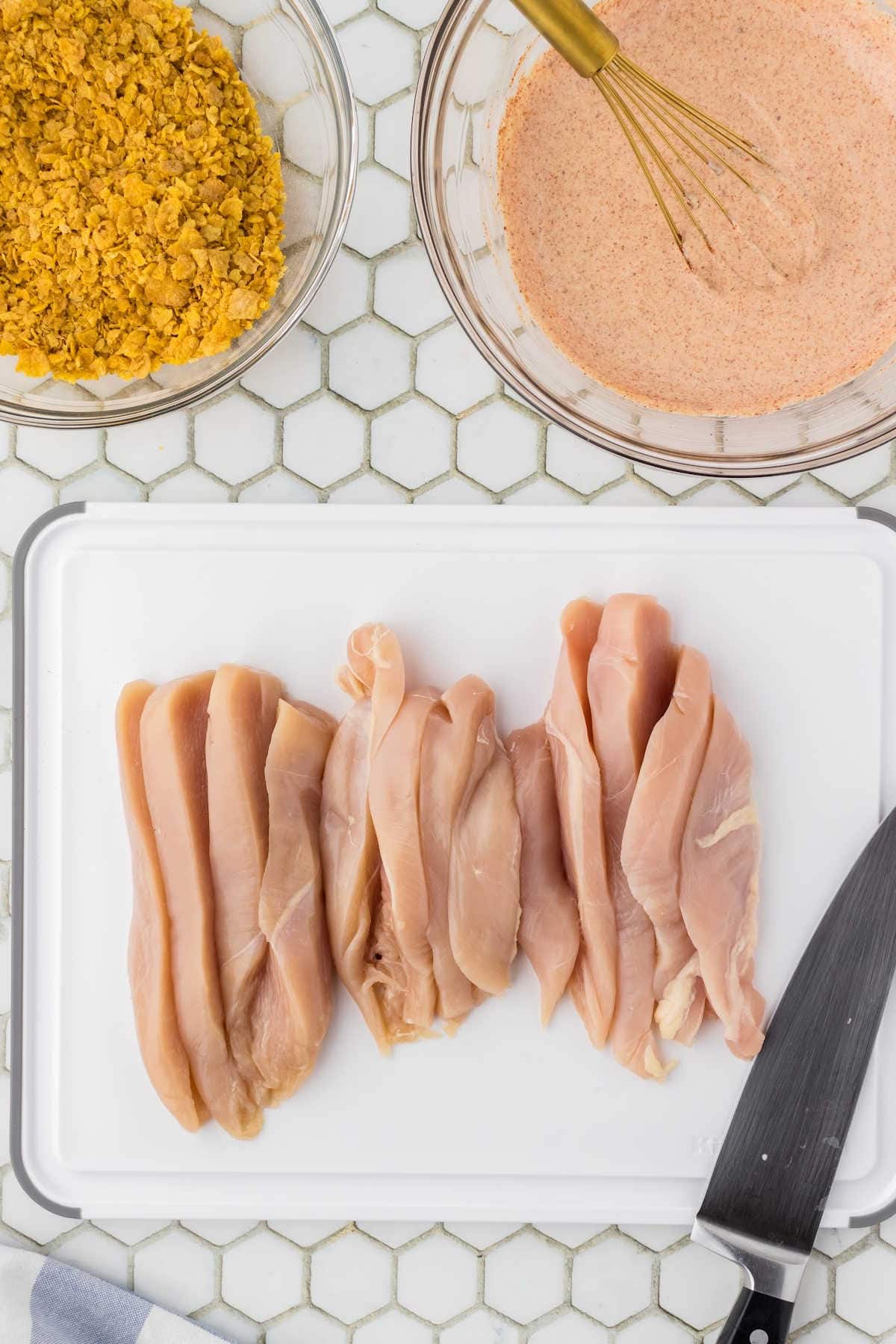 Chicken tenders on a plate ready to be breaded.