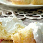 A cupcake cut open on a plate showing the filling. Title text overlay for Pinterest.