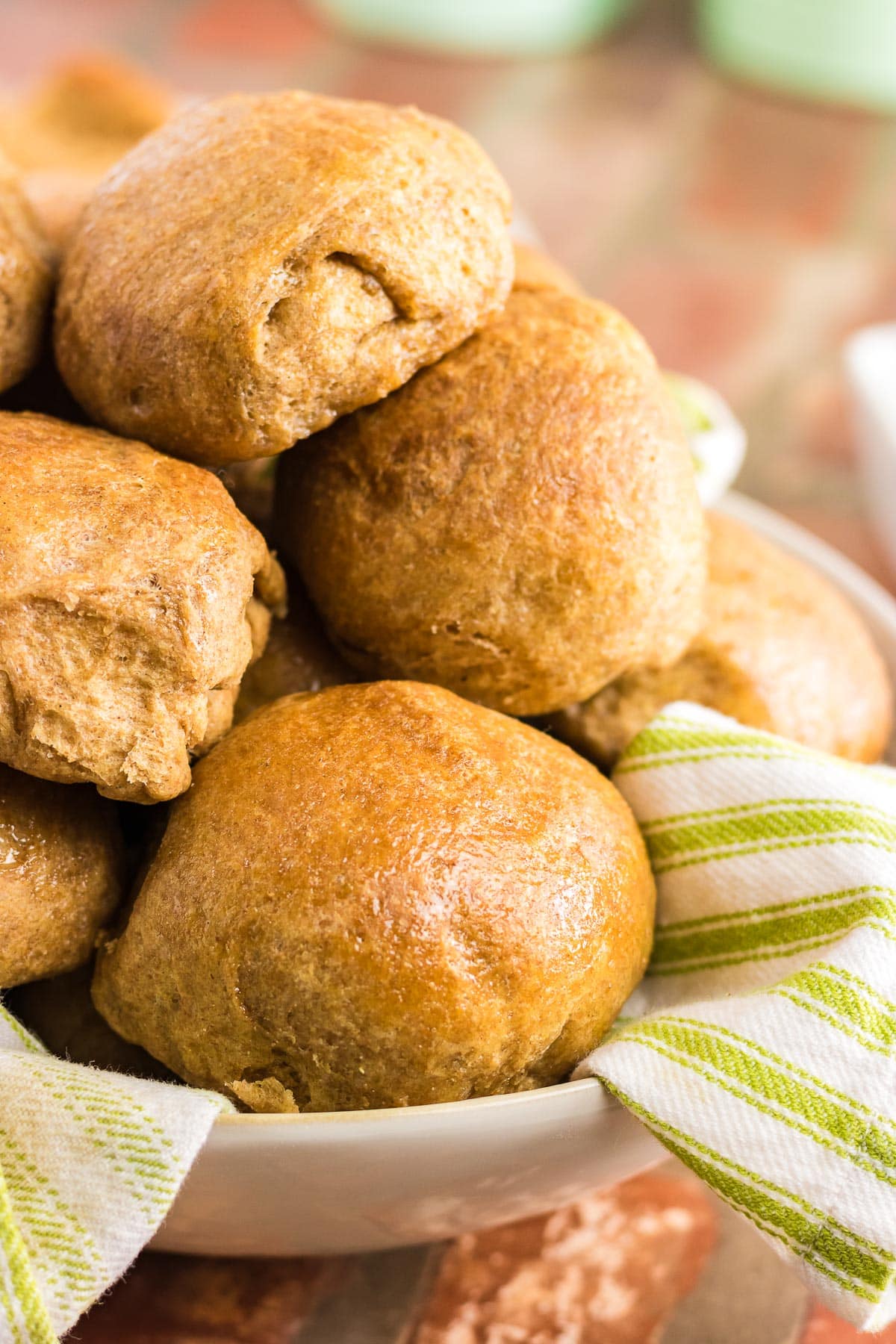 A bowl full of golden brown dinner rolls.