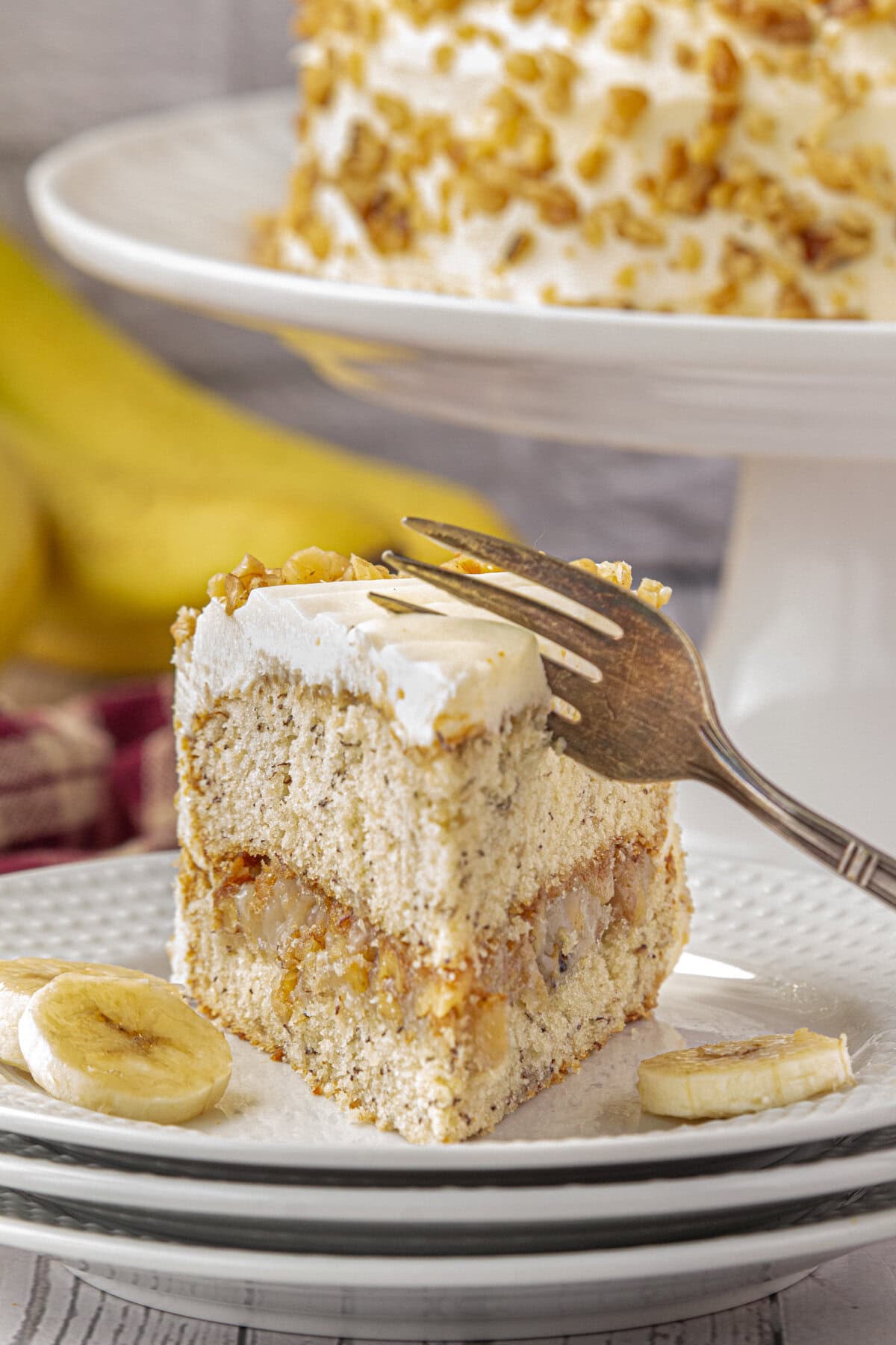 A slice of banana walnut cake with a fork.