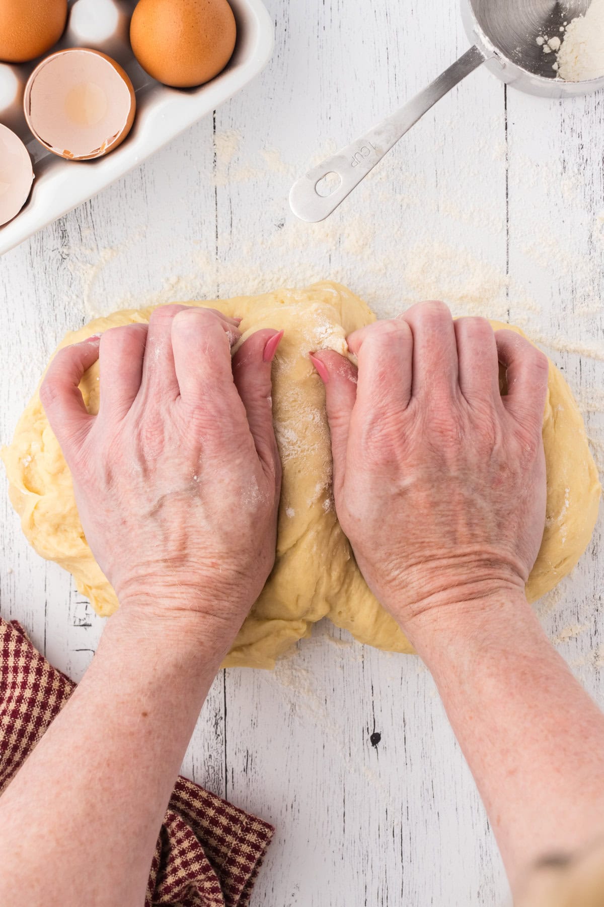Two hands kneading bread dough.