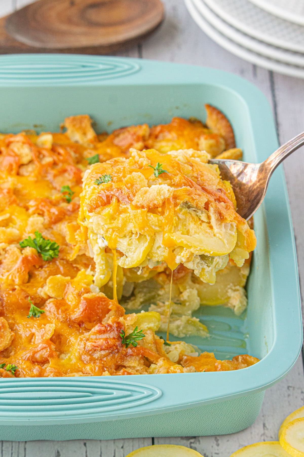 A serving of yellow squash casserole being removed from the dish.