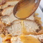 Sauce being drizzled over apple cider pork roast.