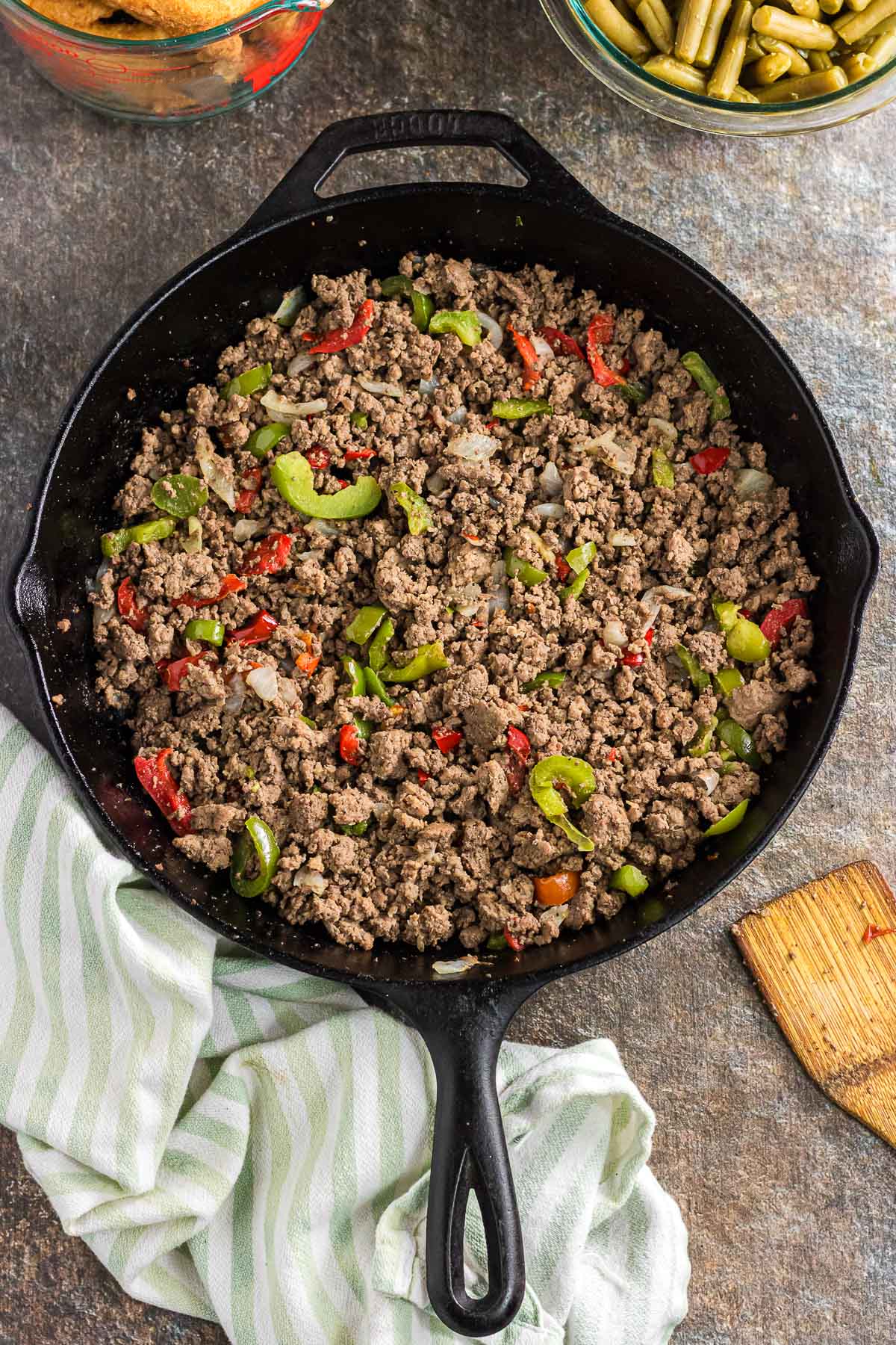 The browned ground beef, peppers, and onions in the skillet.