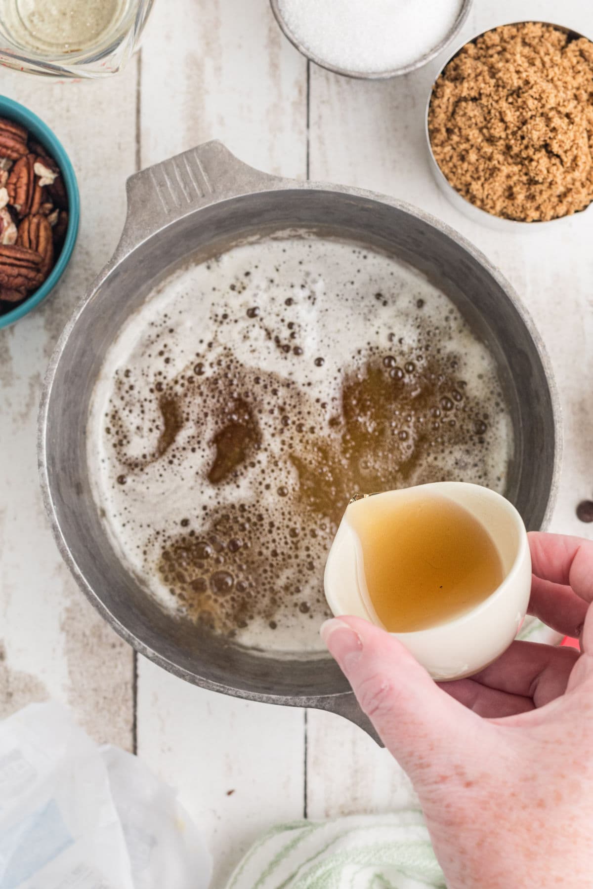 Bourbon being poured into the brown butter.