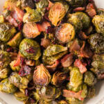 Overhead view of maple roasted brussels sprouts with bacon and cranberries.