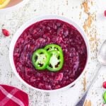 Overhead view of cranberry sauce with sliced jalapenos garnishing the top.
