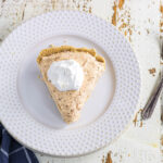 Overhead view of a slice of sweet potato pie with Cool Whip on top.