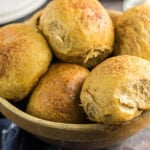 Closeup of sweet potato dinner rolls in a bowl.