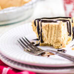 A slice of peanut butter icebox pie with chocolate drizzle.