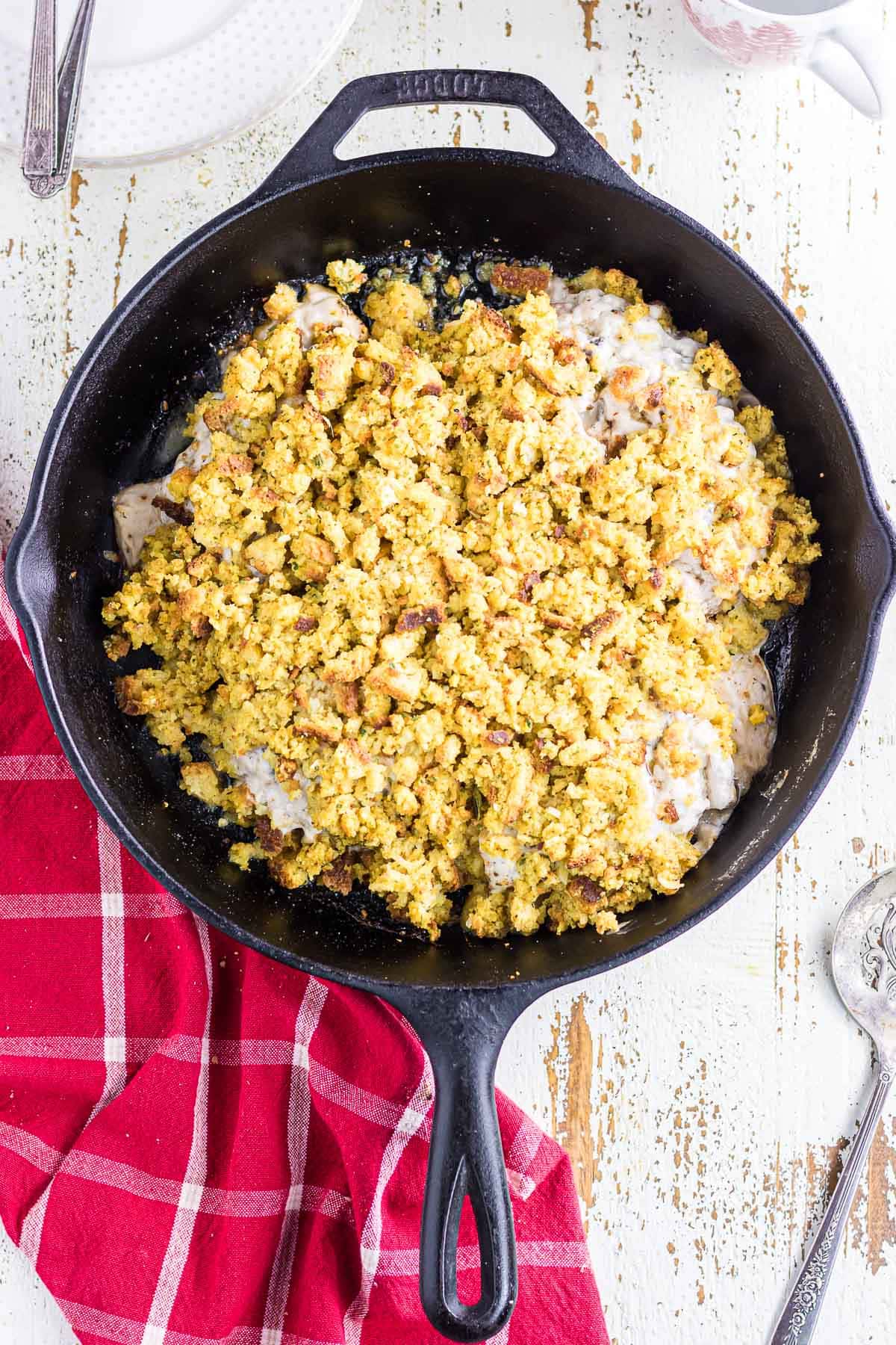 An overhead view of pork chops and stuffing casserole in a skillet.