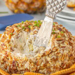 Pineapple pecan cheese ball on a tray with crackers.