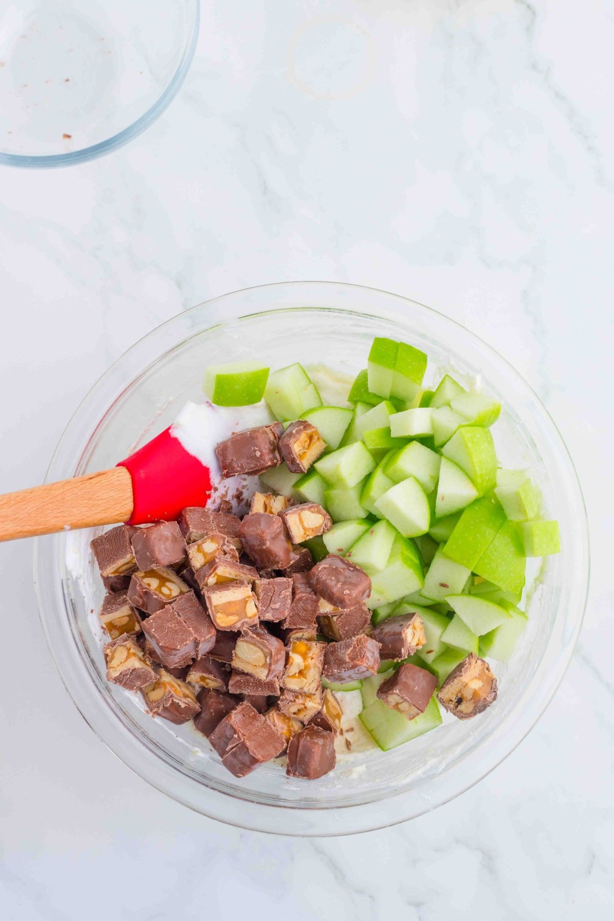 Adding the apples and Snickers bars to the pudding.