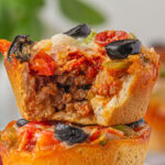 A pizza cup cut open to show the meaty filling.