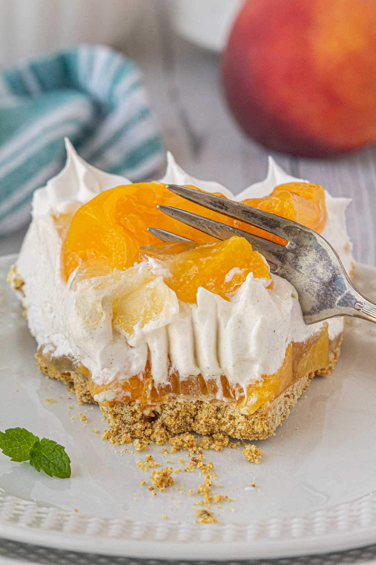 A slice of peach icebox pie being cut with a fork.