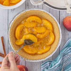 Peaches in the bottom of a pie crust.