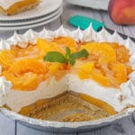 A peaches and cream icebox pie with a serving removed to show the layers.