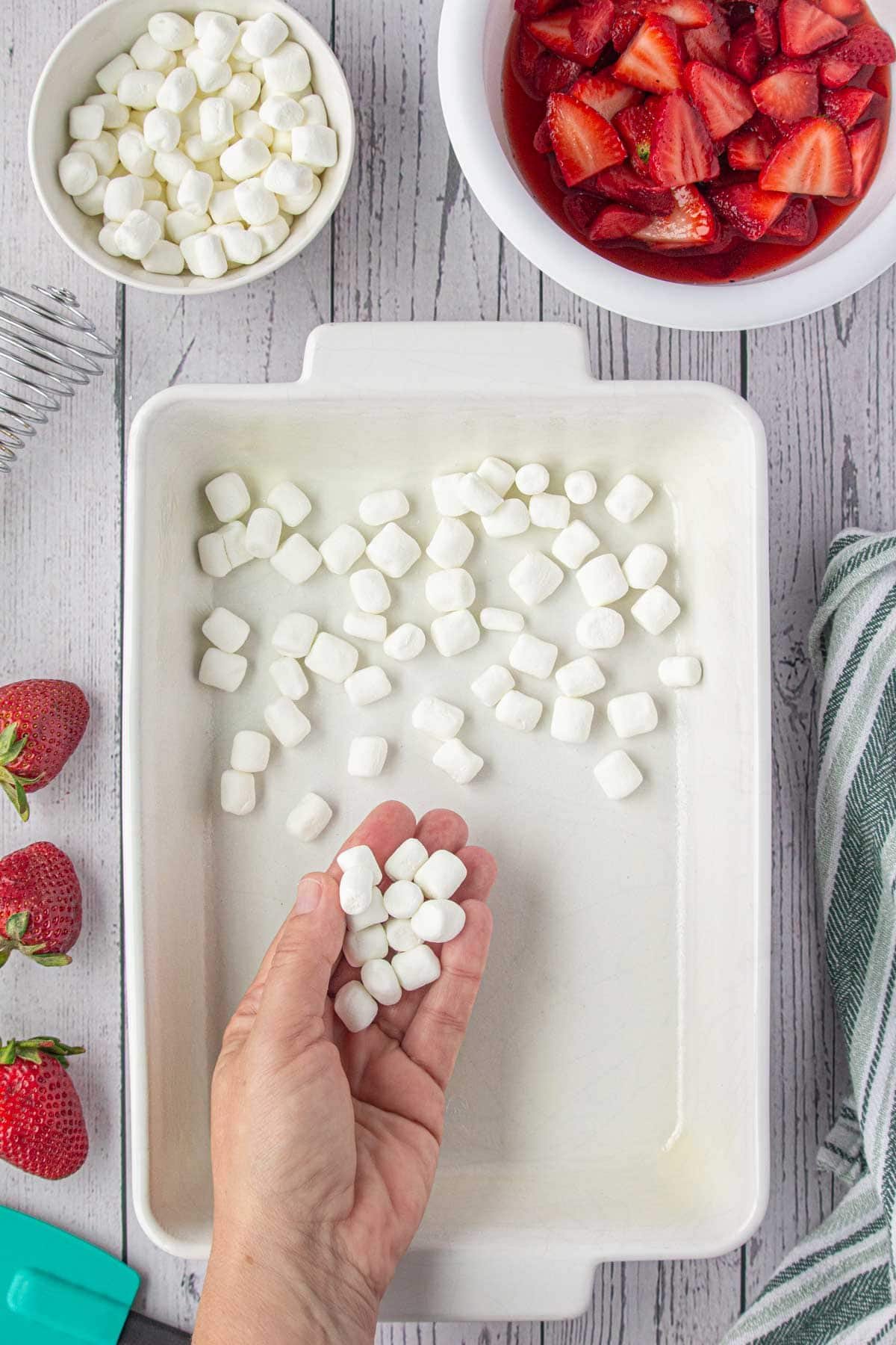 Marshmallows going in the bottom of the cake pan.