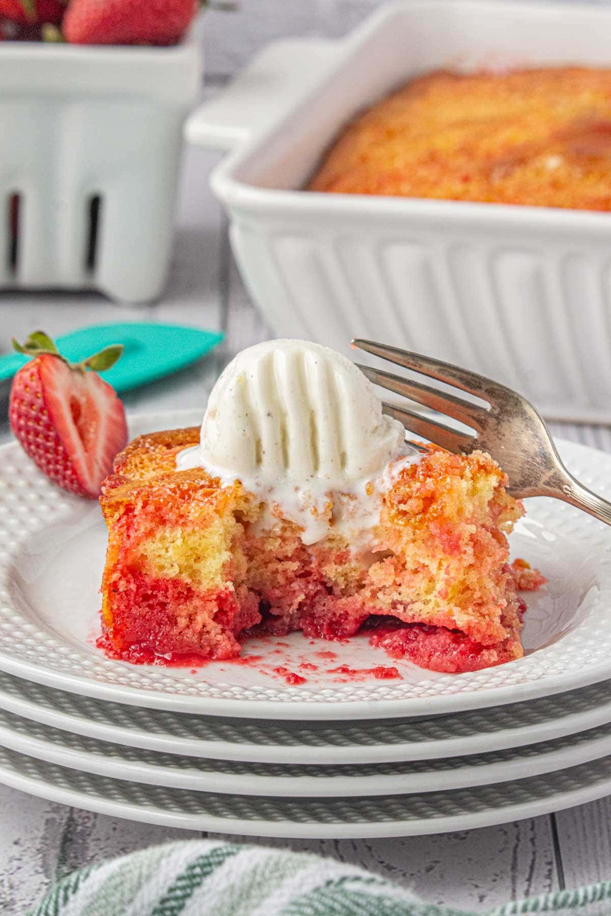 Strawberry shortcut cake on a place with ice cream on top.