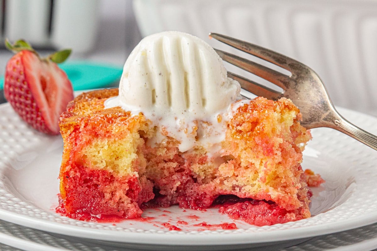 Strawberry shortcut cake, a vintage recipe, on a white plate with ice cream melting on top.
