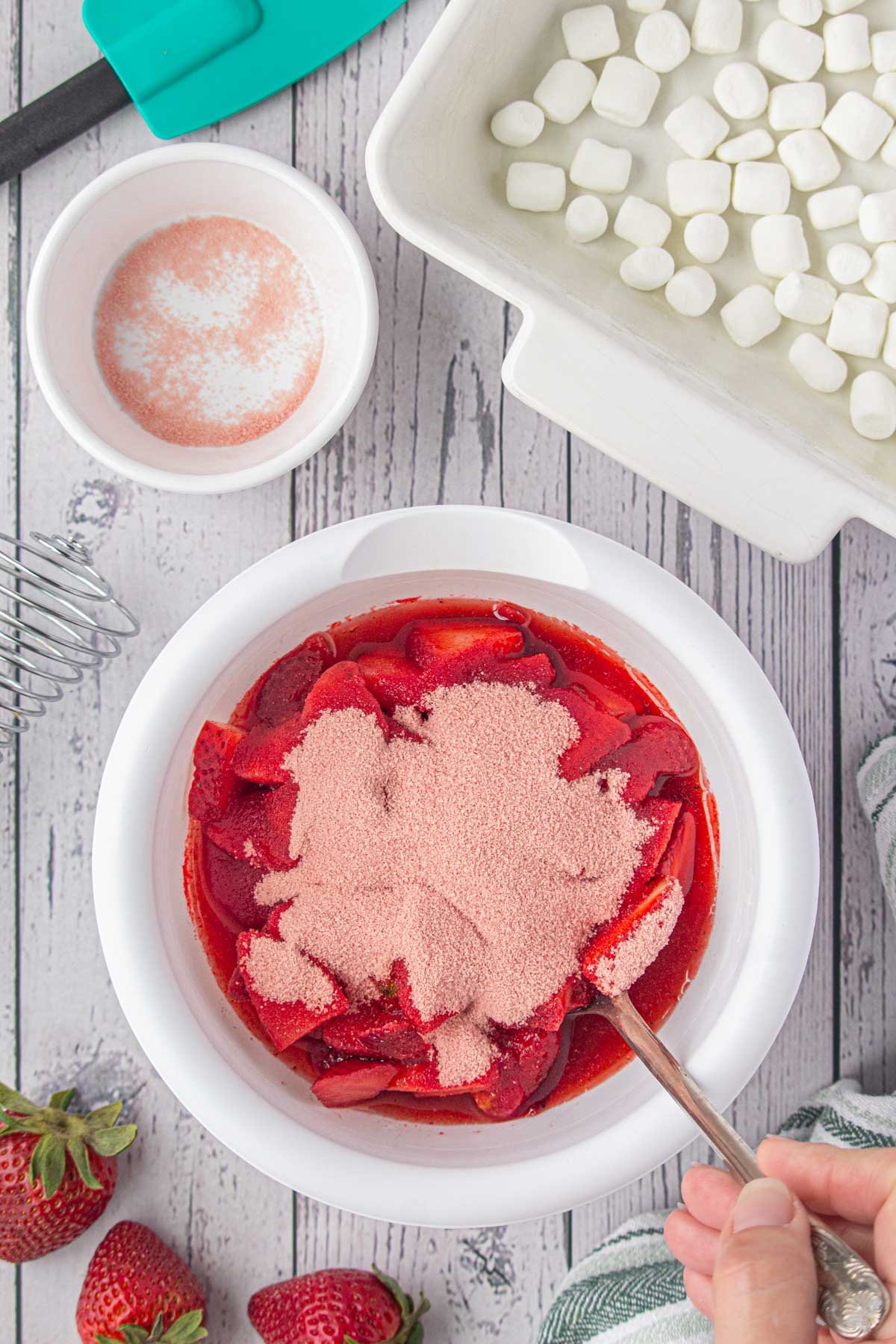 Jell-o powder being stirred into thawed berries.