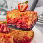 A square of strawberry shortcut cake being served from a spatula.