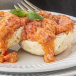 Closeup of Southern tomato gravy over a fluffy, buttermilk biscuit.