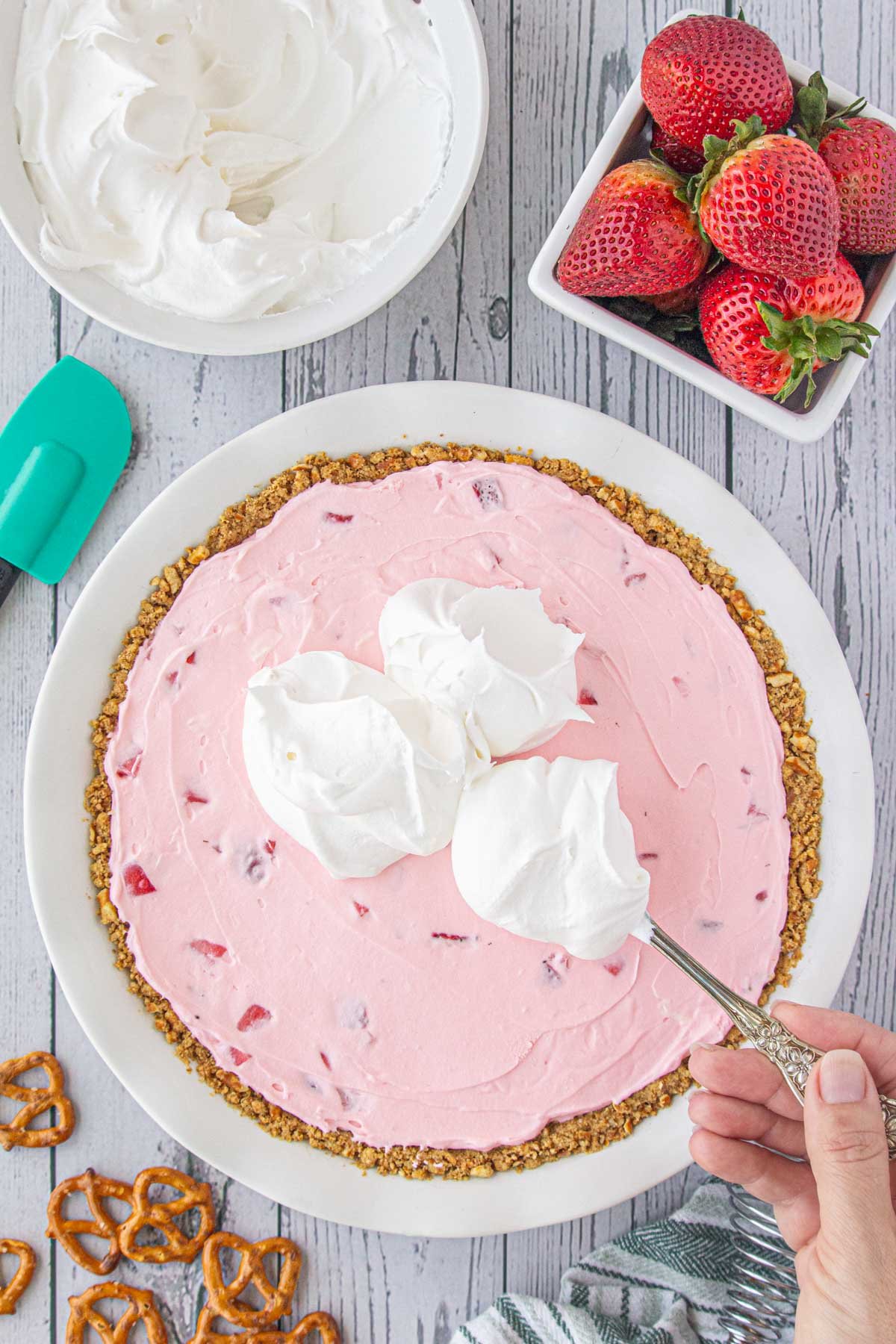 Cool Whip being spooned over the finished pie.