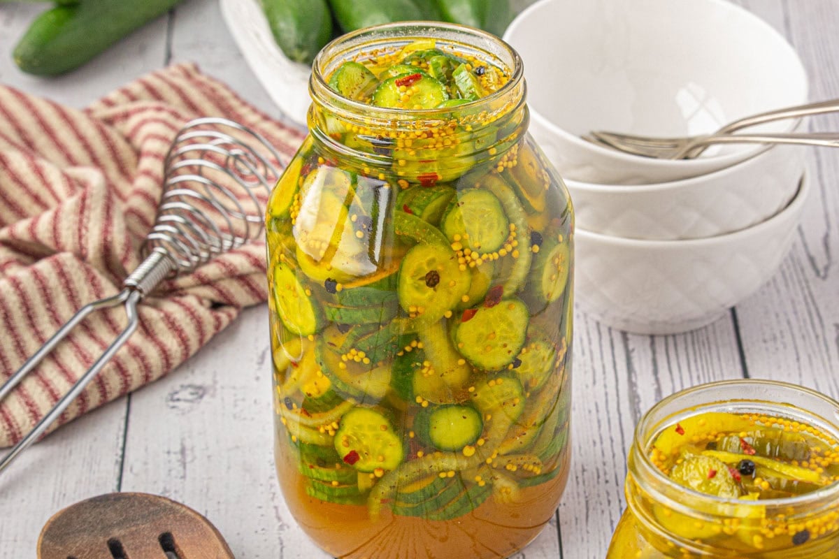 A jar of refrigerator pickles on the table, ready to eat.