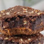 Closeup of a caramel fudge brownie with pecans on top.