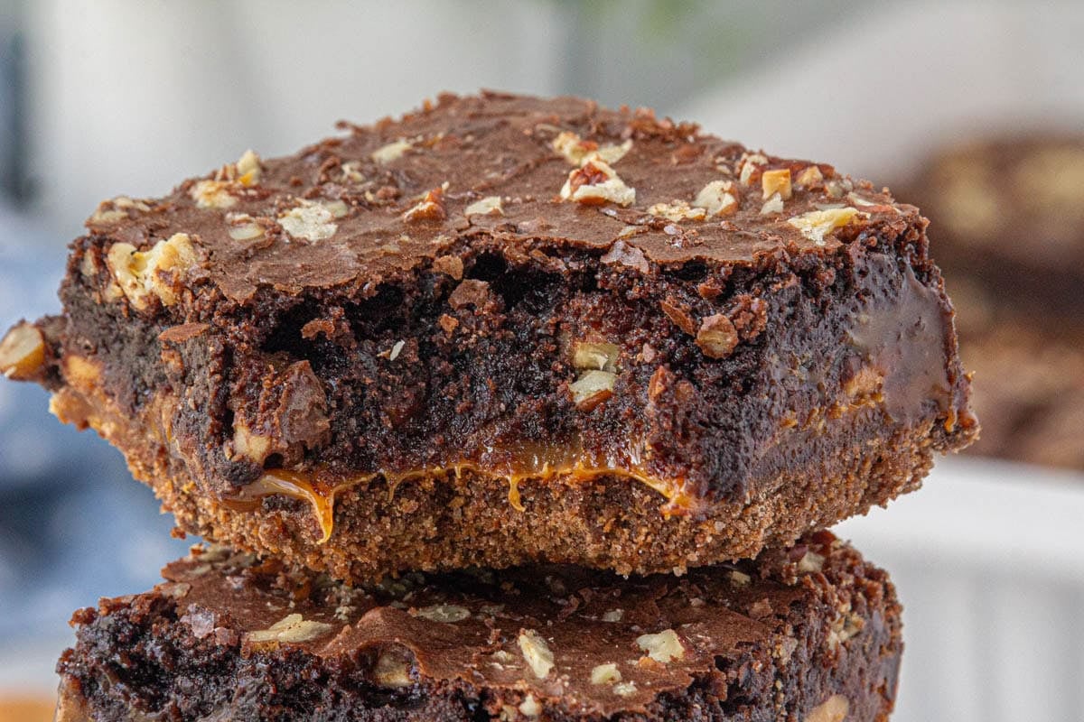 Closeup of a caramel fudge brownie with pecans on top.