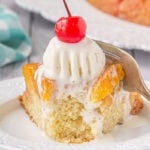 A square of peach upside-down cake with ice cream on top.