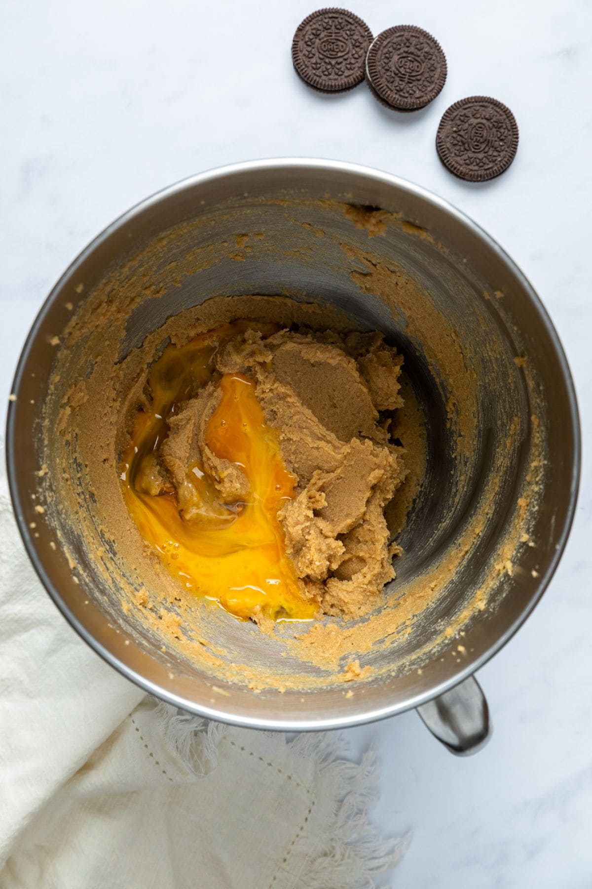 Eggs and vanilla being beaten into the creamed butter and sugar mixture.