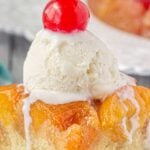 A slice of peach upside down cake with vanilla ice cream and a cherry on top has a title text overlay for Pinterest.