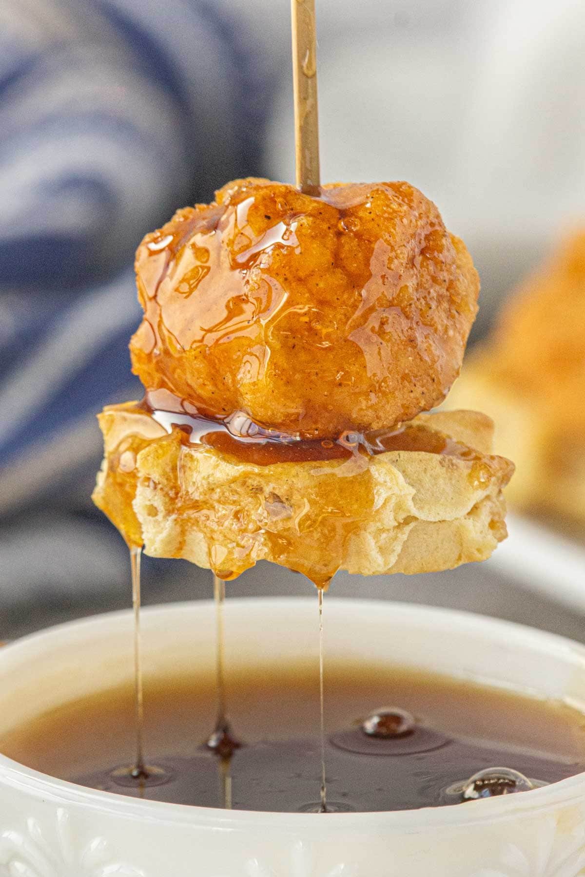 Closeup of hicken and waffle skewers dipped in spicy maple syrup.