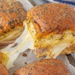 A hot ham and muenster cheese slider being served.