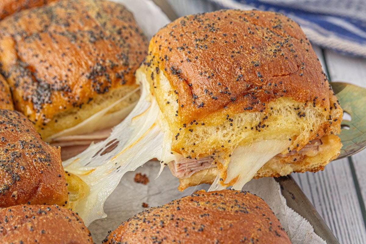 A hot ham and muenster cheese slider being served.