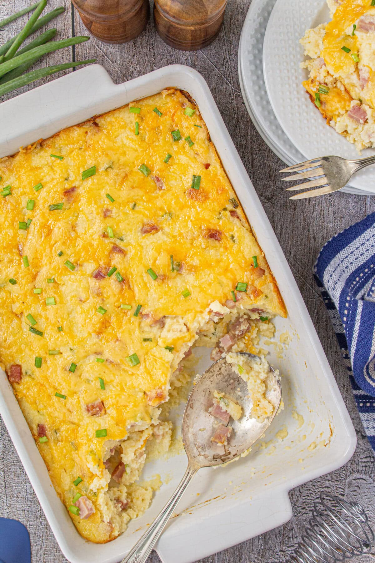 Overhead view of this Southern cheesy ham and grits breakfast bake with a serving removed.