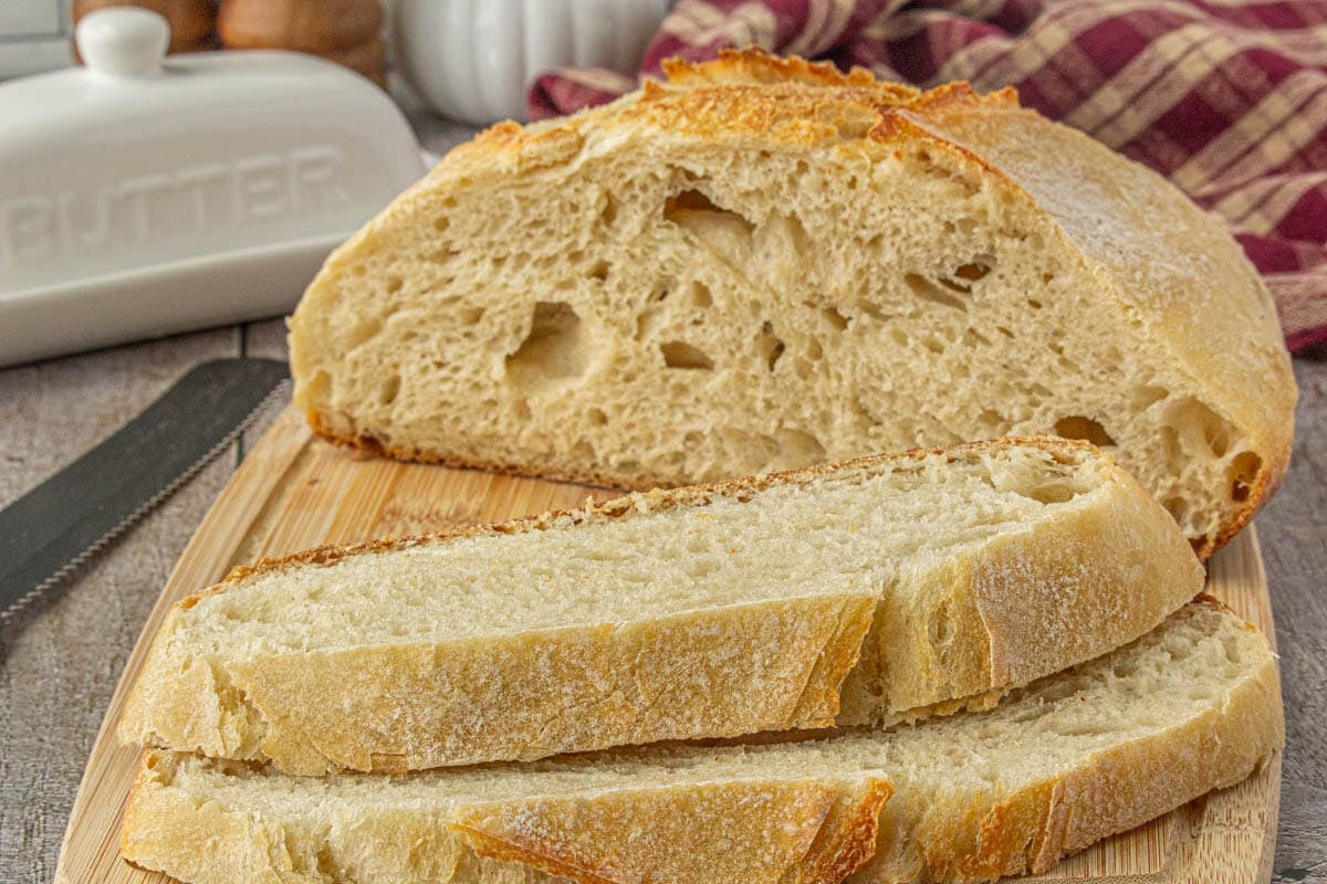A loaf of sourdough bread sliced on a cutting board.