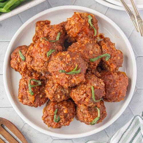 Overhead view of a plate filled with slow cooker porcupine meatballs made with tomato soup.