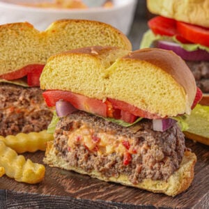 Pimento cheese stuffed burger cut in half to show the cheesy middle oozing out.