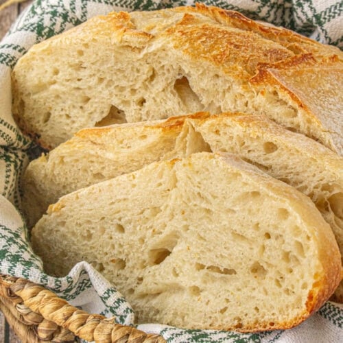 Sliced sourdough bread loaf in a bread basket.
