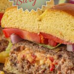 Pimento cheese stuffed burger on a bun is cut in half showing the cheese oozing out. Title text overlay for Pinterest reads "Pimento Cheese Stuffed Burger".