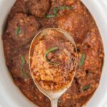 Overhead view of a crockpot with porcupine meatballs in a tomato soup sauce and a title text overlay for Pinterest.