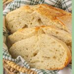Sliced sourdough bread in a bread basket with title text overlay for Pinterest.