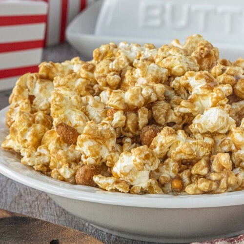 Close-up of a bowl of homemade Cracker Jack caramel popcorn with peanuts, showing glossy golden coating and crunchy clusters.