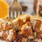 Gooey crockpot monkey bread drizzled with orange glaze and topped with pecans — warm pull-apart bread perfect for Christmas breakfast.
