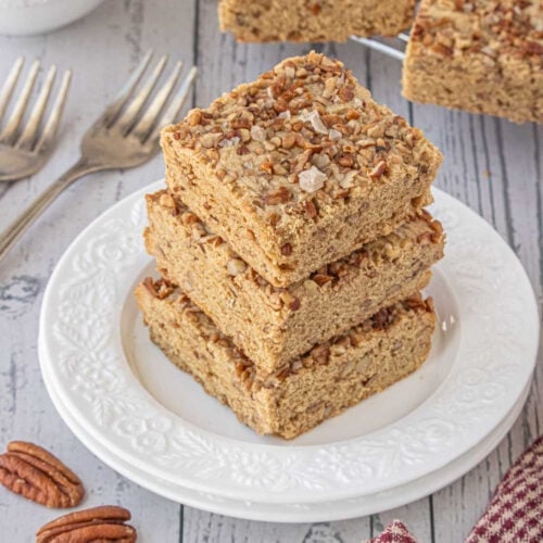 Soft and chewy maple pecan blondies stacked on a white plate, easy homemade blondie bars with maple syrup and toasted pecans.